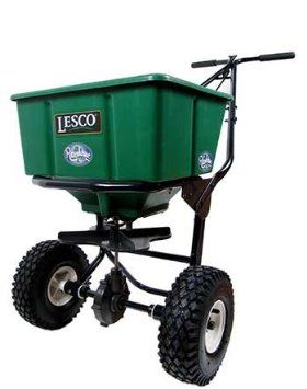 Green Lesco spreader with large wheels, used for spreading granular fertilizer on lawns.