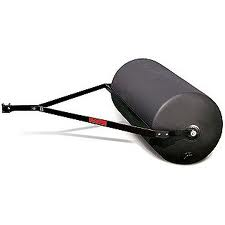 Lawn roller with black cylindrical drum and metal frame; used to flatten soil or grass.