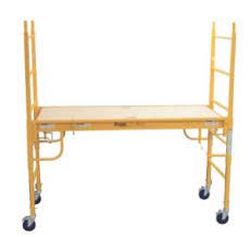 Yellow scaffolding with a wooden platform, on wheels.