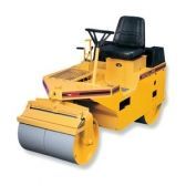 Yellow road roller compacting pavement.