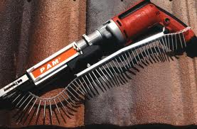 Red and silver PAM screw gun with a strip of screws, on a brown roof.
