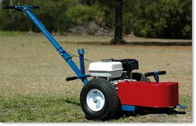 Blue and red lawn striping machine on grass; white tire; blue handle.