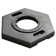 Black, hexagonal, recycled rubber base for traffic control posts, with a central hole and two slots.
