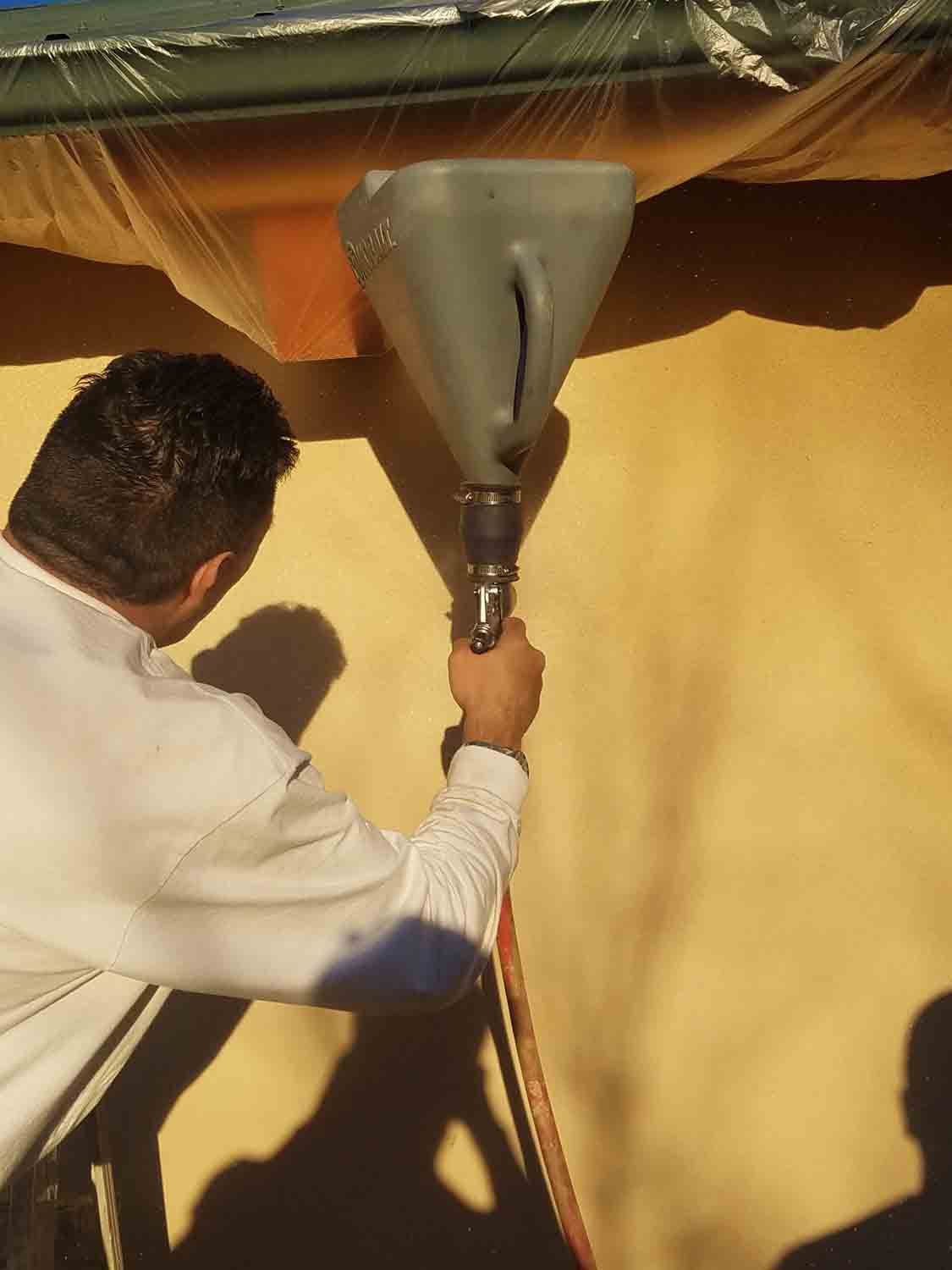 A man is using a hose to fill a container with water