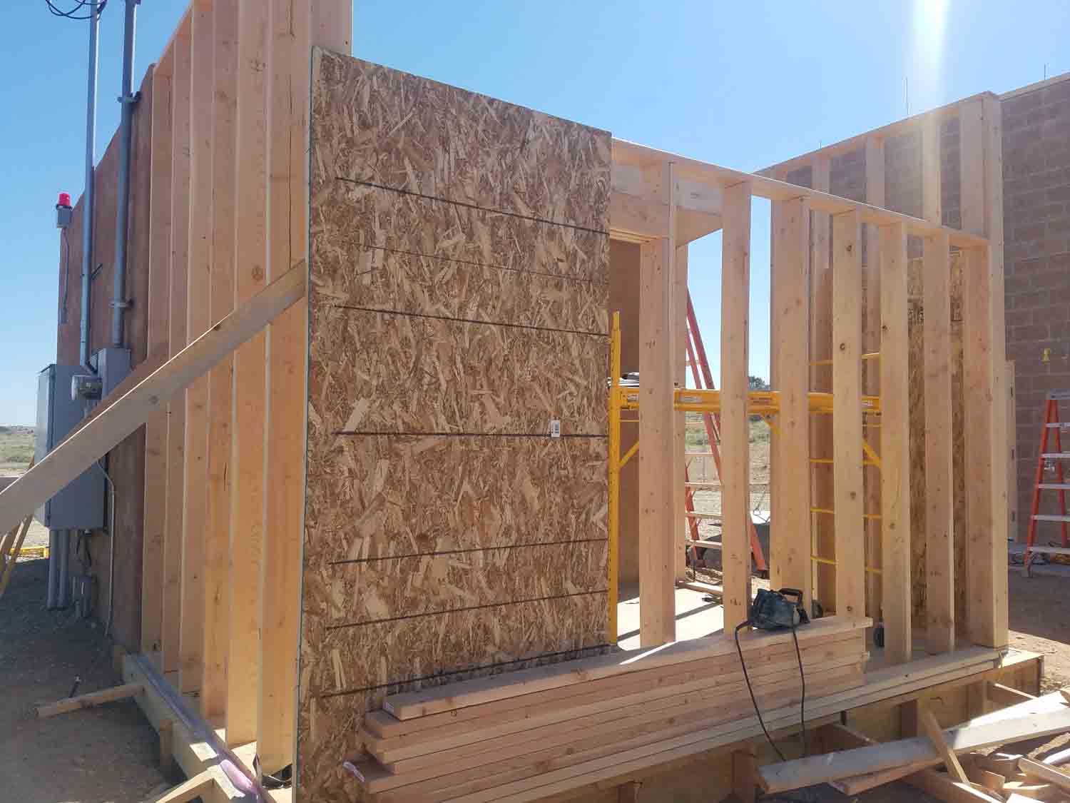 A wooden wall is being built on a construction site.