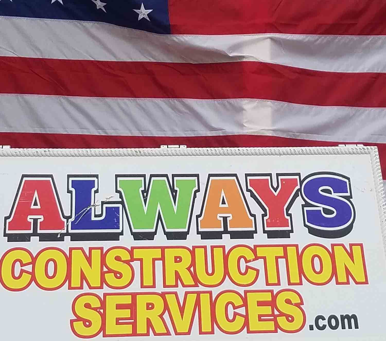 A sign for always construction services with an american flag in the background