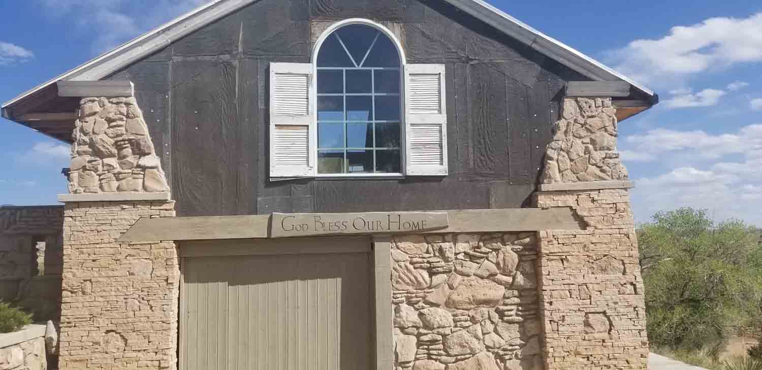A large stone building with a garage door and a window.