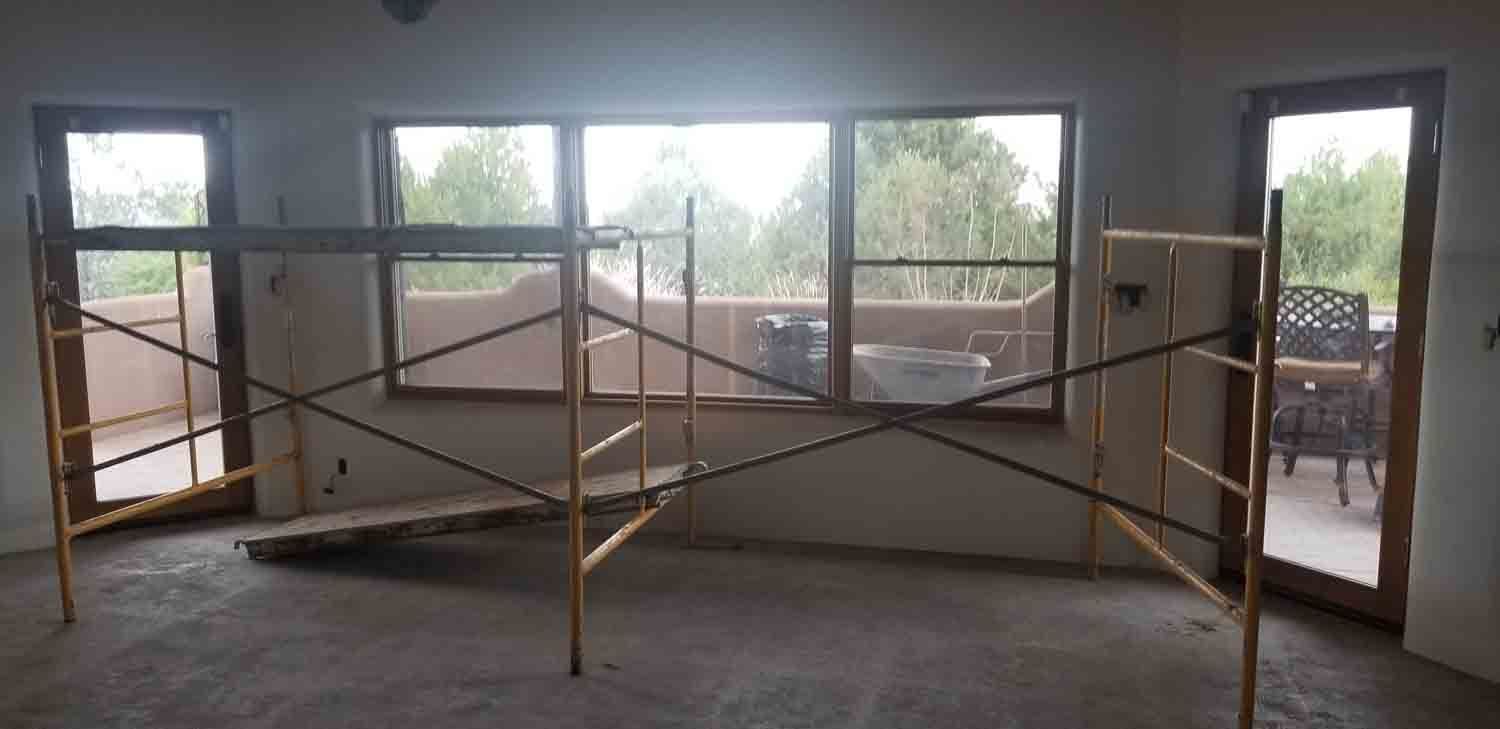 A room with a scaffolding in it and a lot of windows.