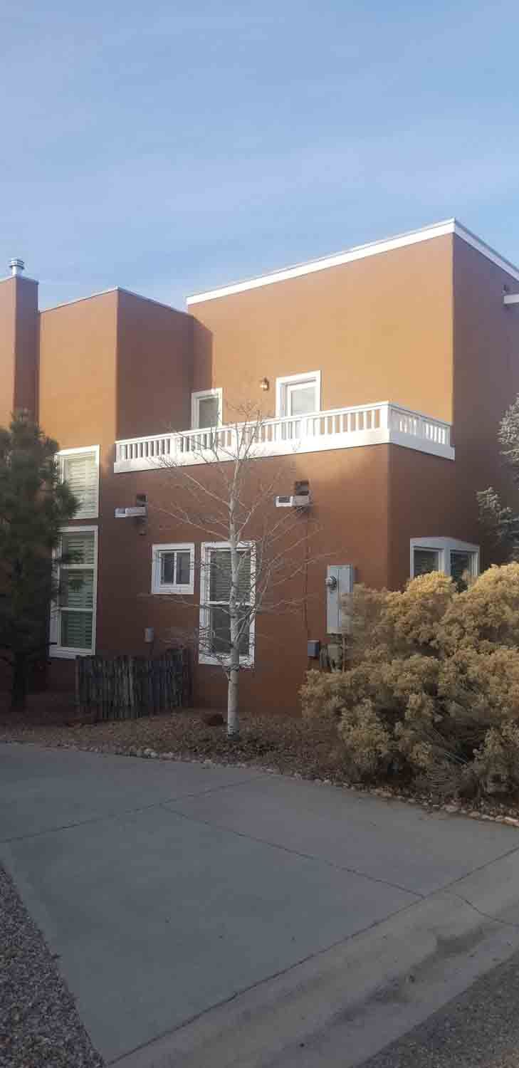 A large brown building with a balcony on the top of it.
