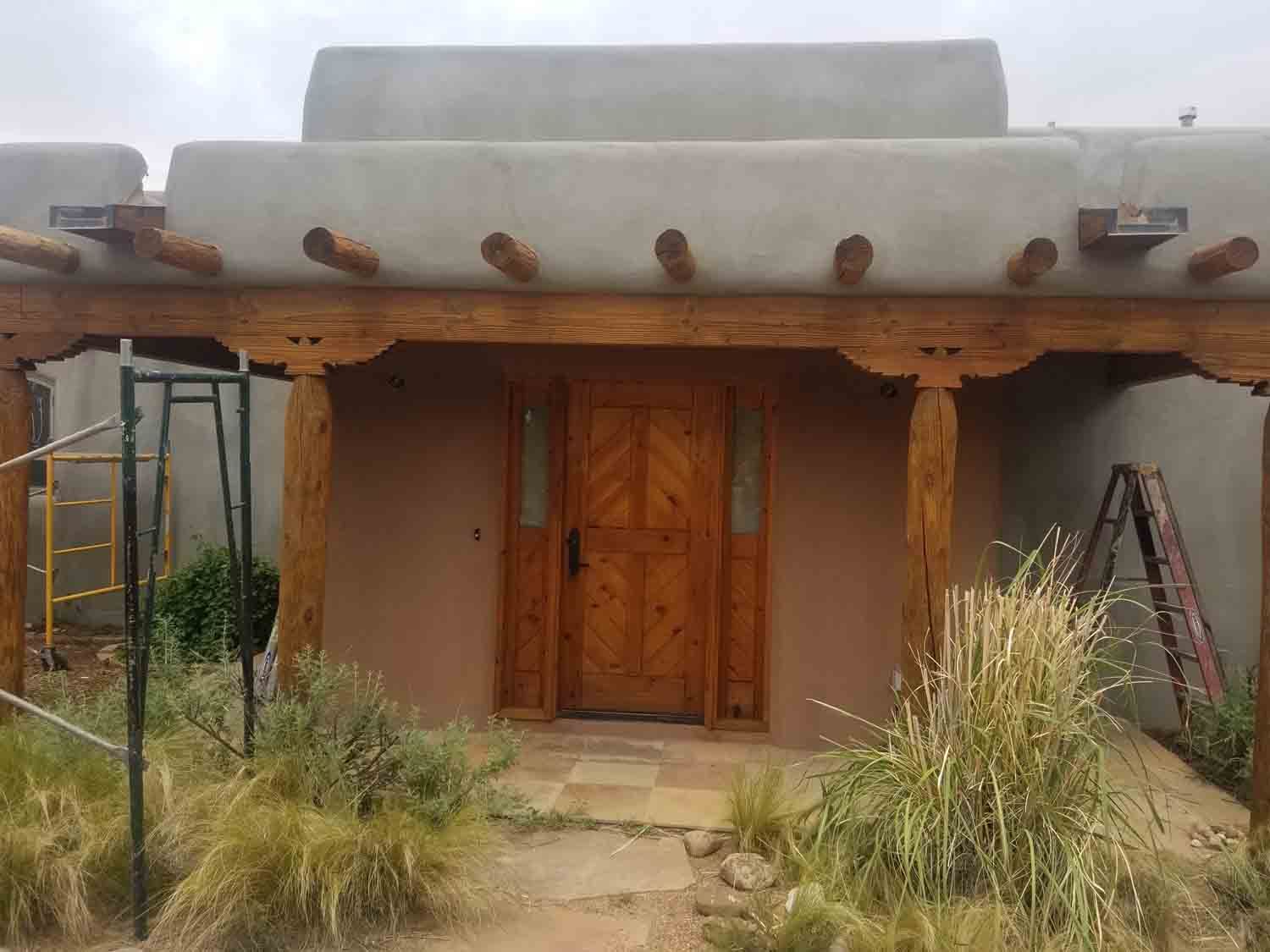 The front of a house with a wooden door and a porch.