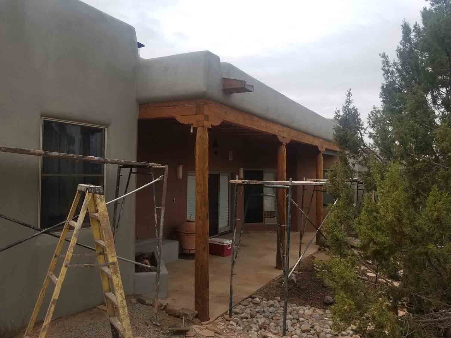 A ladder is sitting in front of a house under construction.