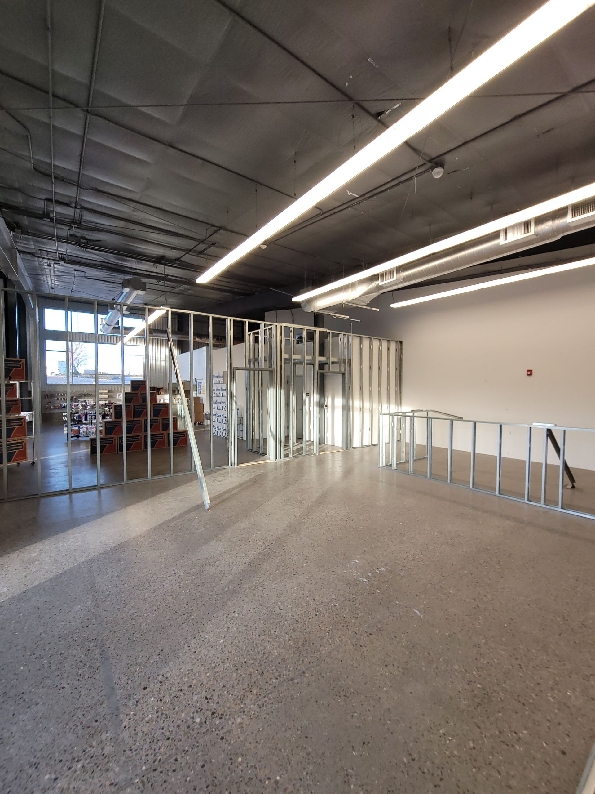 A large empty room with a ladder in the middle of it