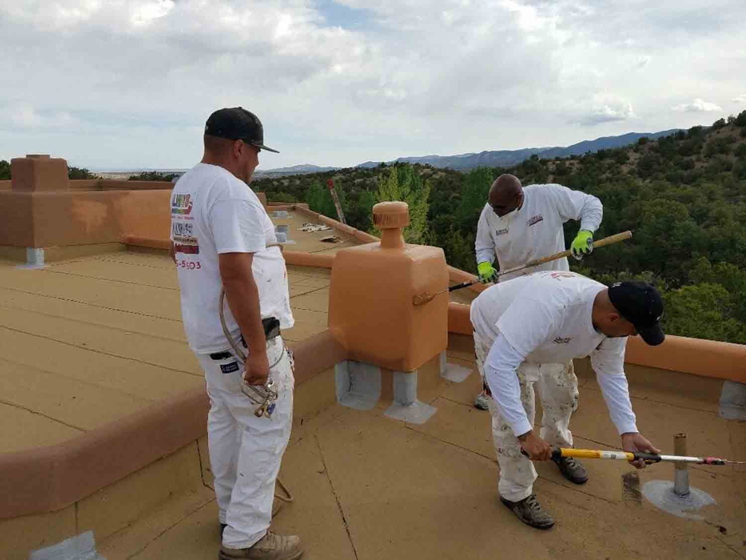 Three men are working on the roof of a building.