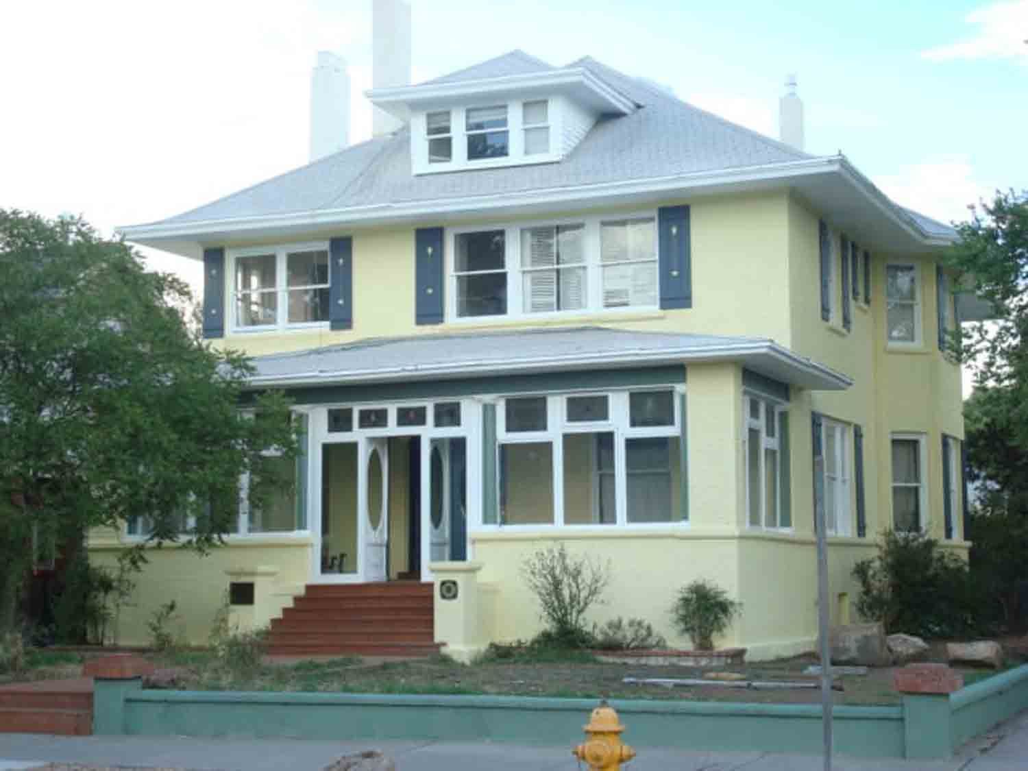 A yellow house with a fire hydrant in front of it