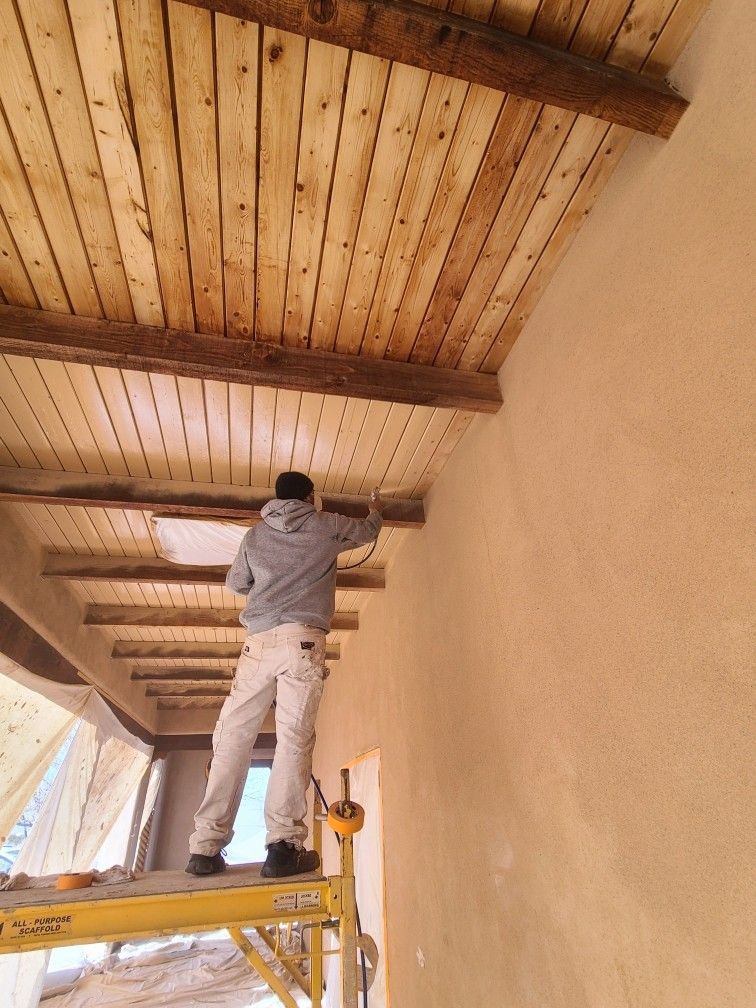 A man is painting the ceiling of a building