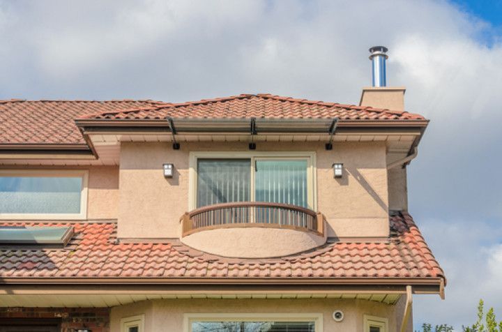 A large house with a tiled roof and a balcony.