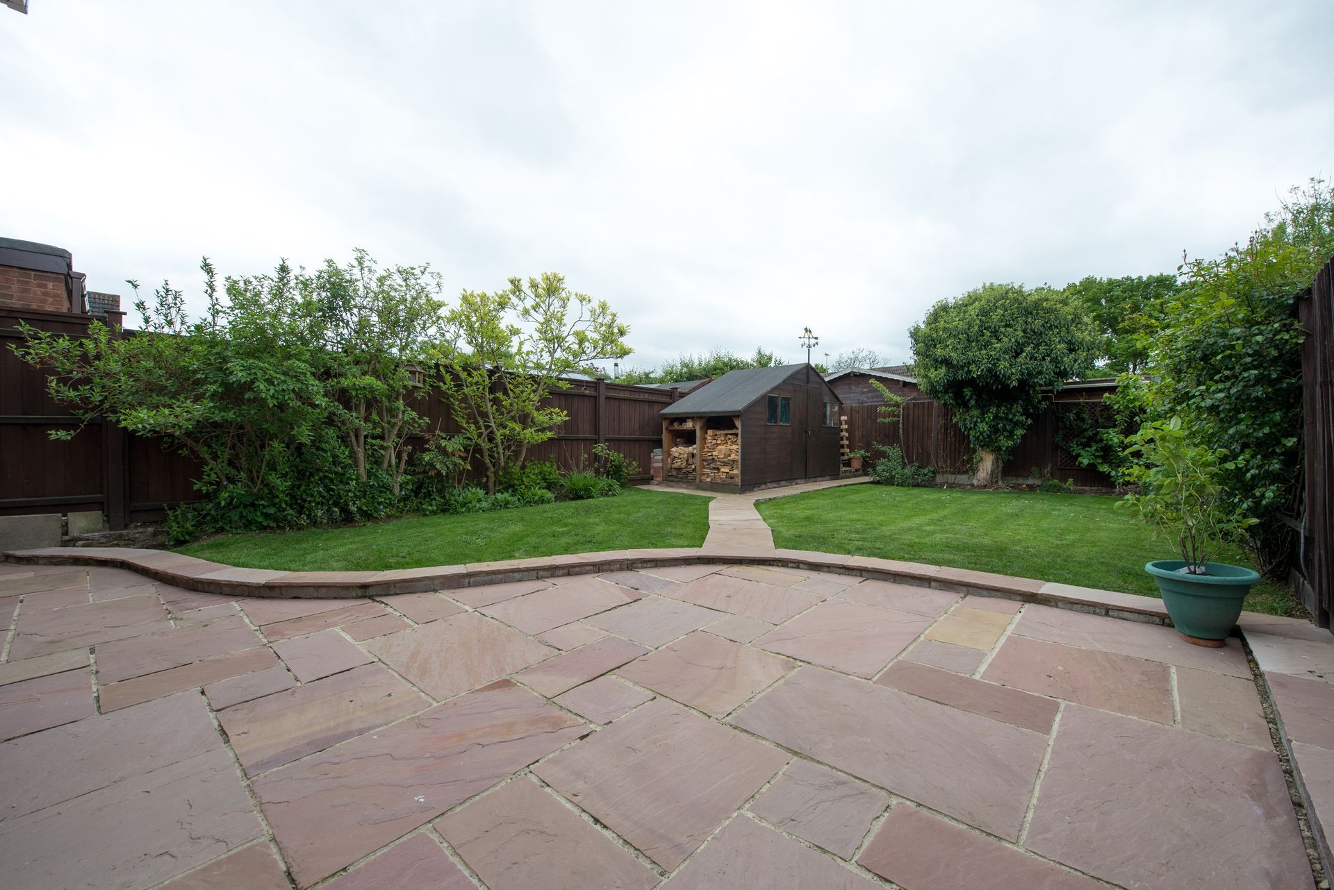 Beautiful paver patio in a lush garden setting, perfect for outdoor relaxation and entertaining.[