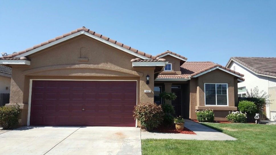 The front of a house with a red garage door