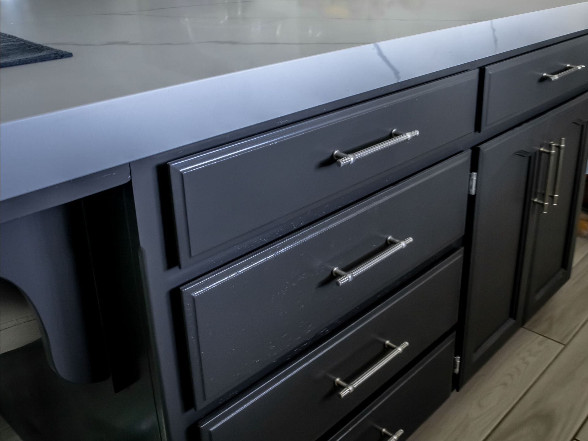 A kitchen with black cabinets and silver handles