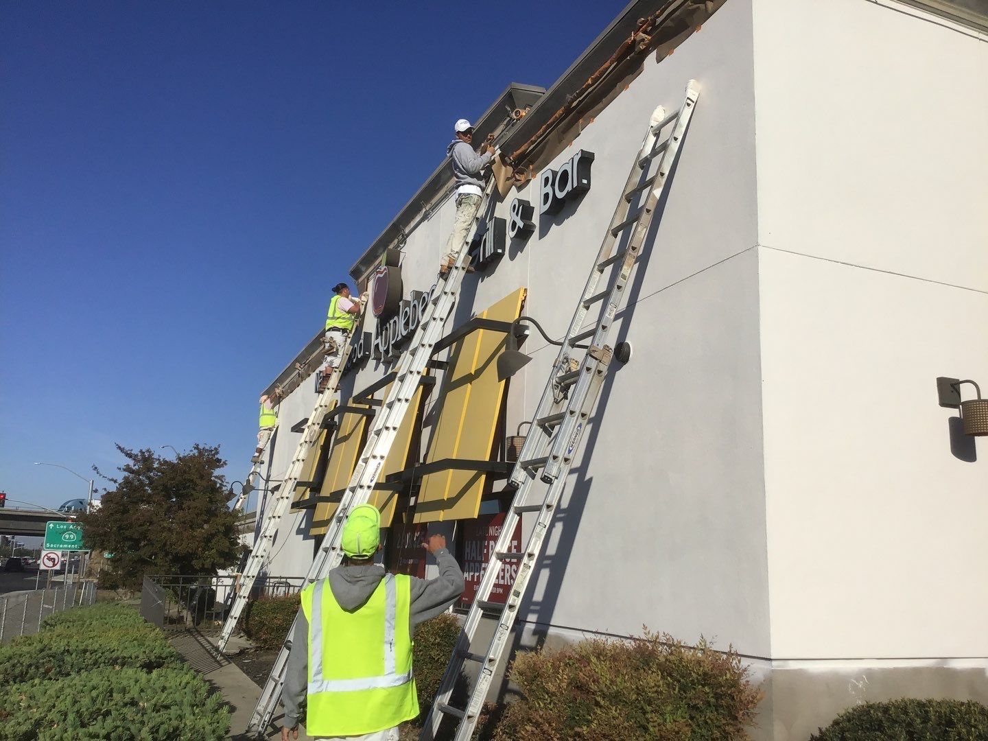 A group of Lancaster Painting employees are painting the side of a building.