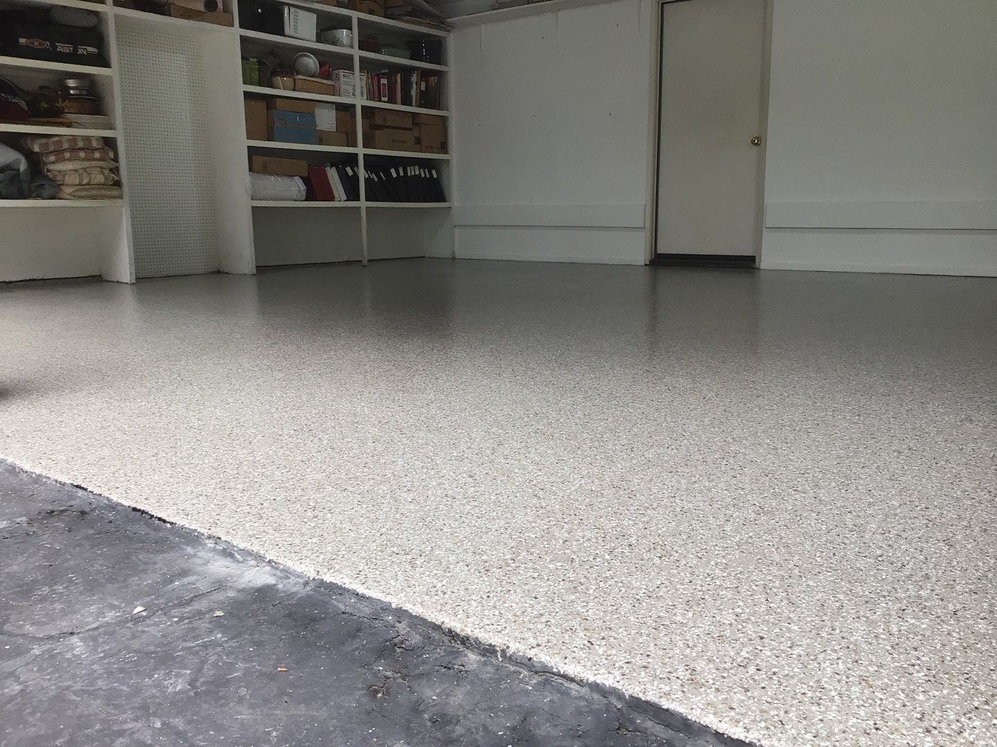 A garage with a concrete floor and shelves.