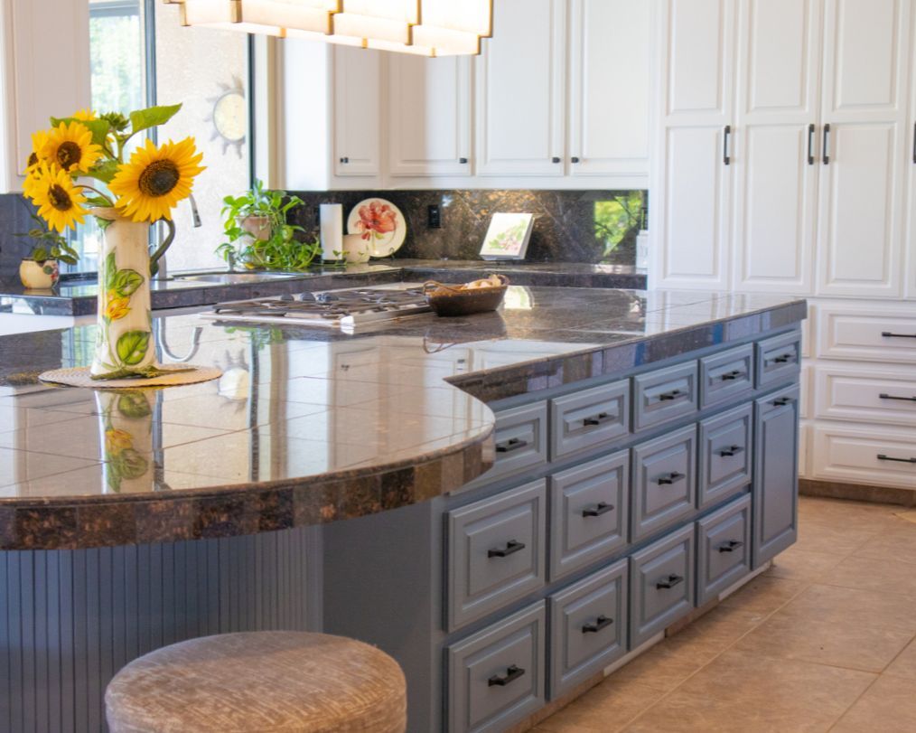 A kitchen with a large island and a vase of sunflowers on the counter