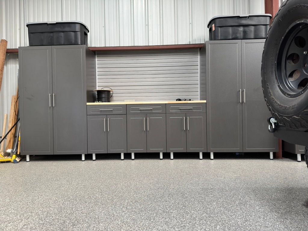 A garage filled with lots of cabinets and a tire.