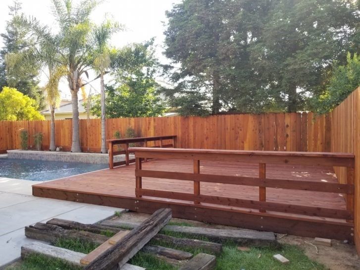 A wooden deck with a wooden fence surrounding it