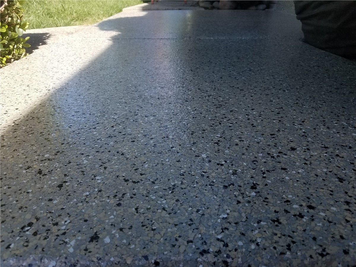 A close up of a concrete floor with a lot of small stones on it.