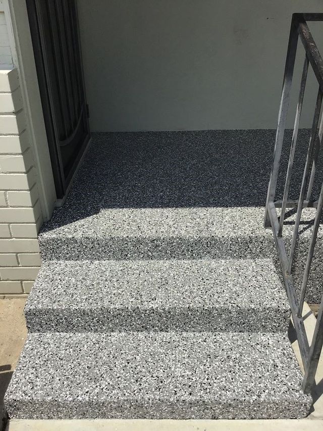 A set of stairs leading up to a door with a metal railing.