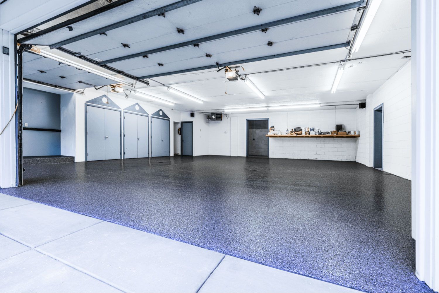 A large empty garage with a garage door open.