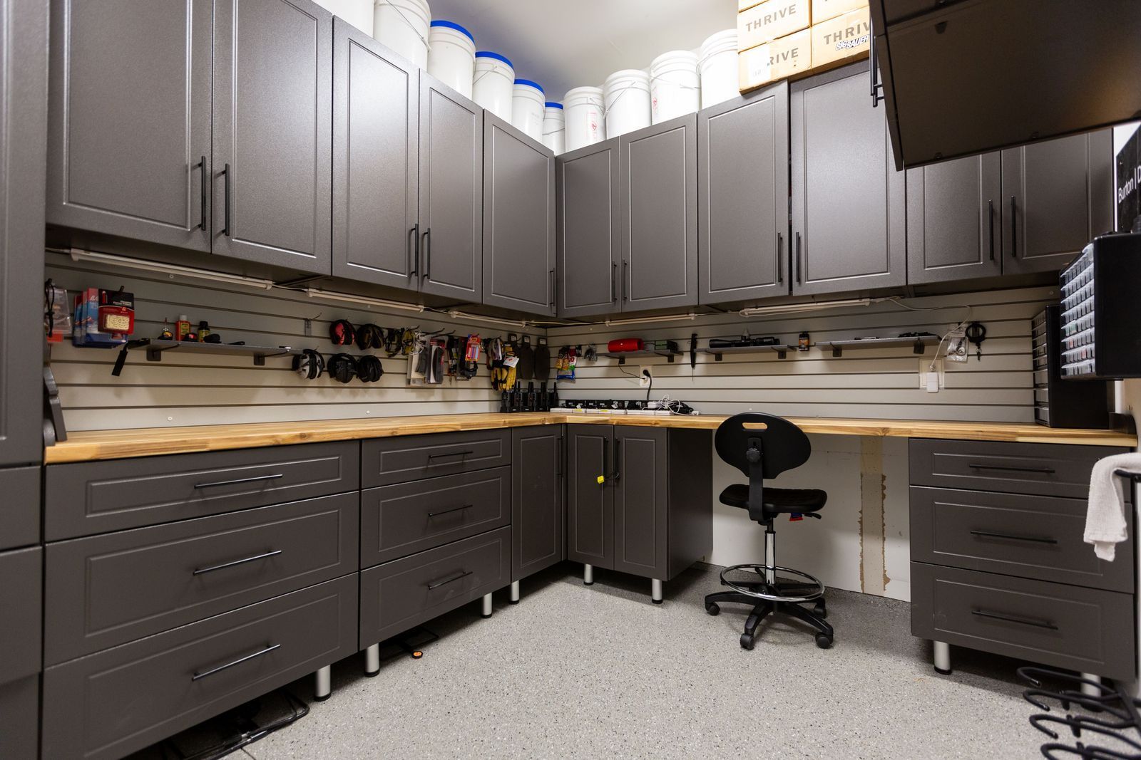 A large garage with lots of cabinets and drawers and a workbench.
