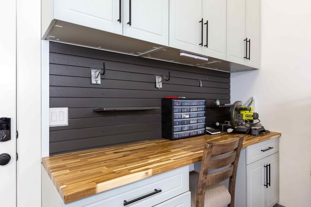 A kitchen with a wooden counter top and a wooden chair.