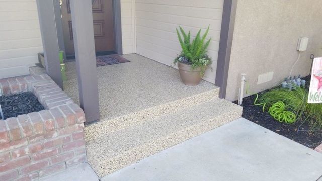 There is a potted plant on the porch of a house.