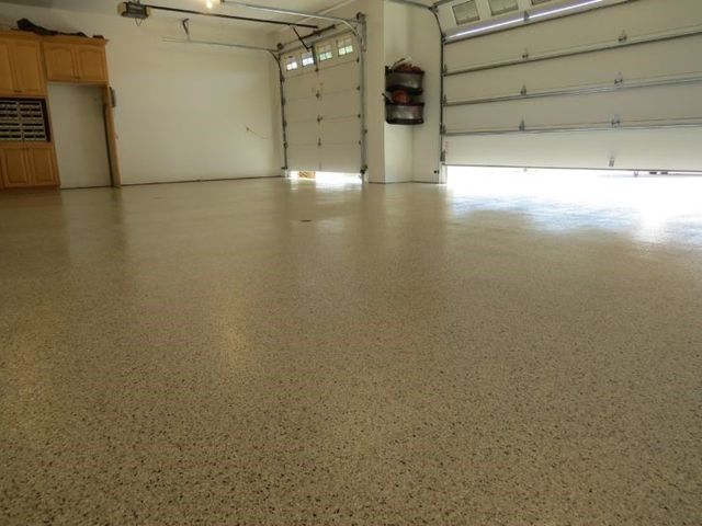 A garage with a garage door open and a shiny floor