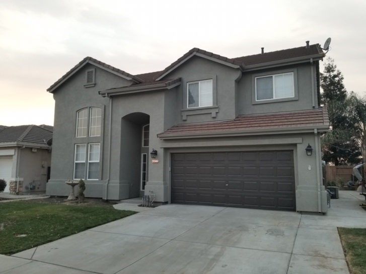 A large gray house with a garage and a driveway