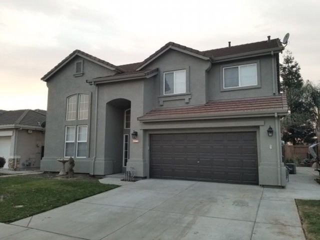 A large gray house with a garage and a driveway