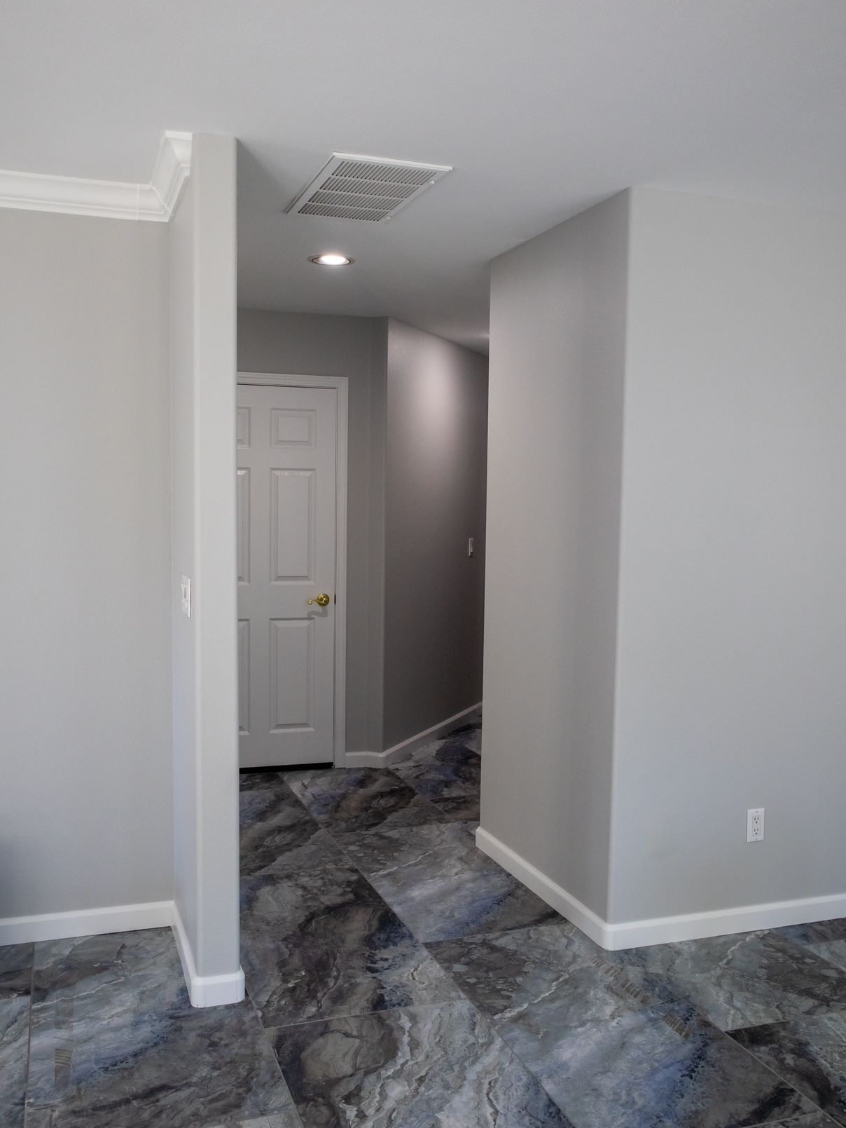An empty room with a door and a tiled floor.