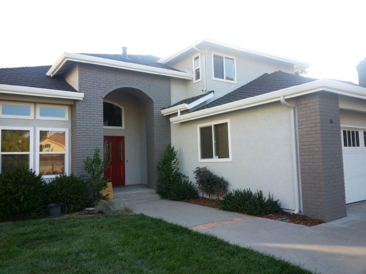 A large house with a red door and a white garage door