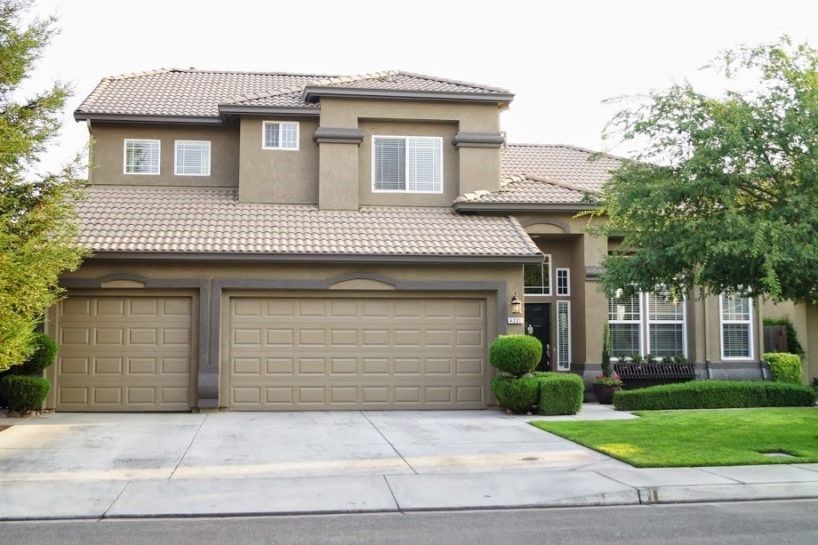 A large house with two garage doors and a driveway