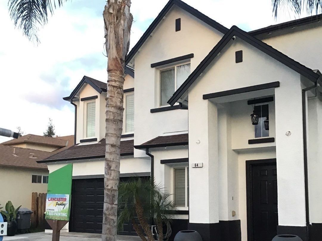 A white house with a palm tree in front of it