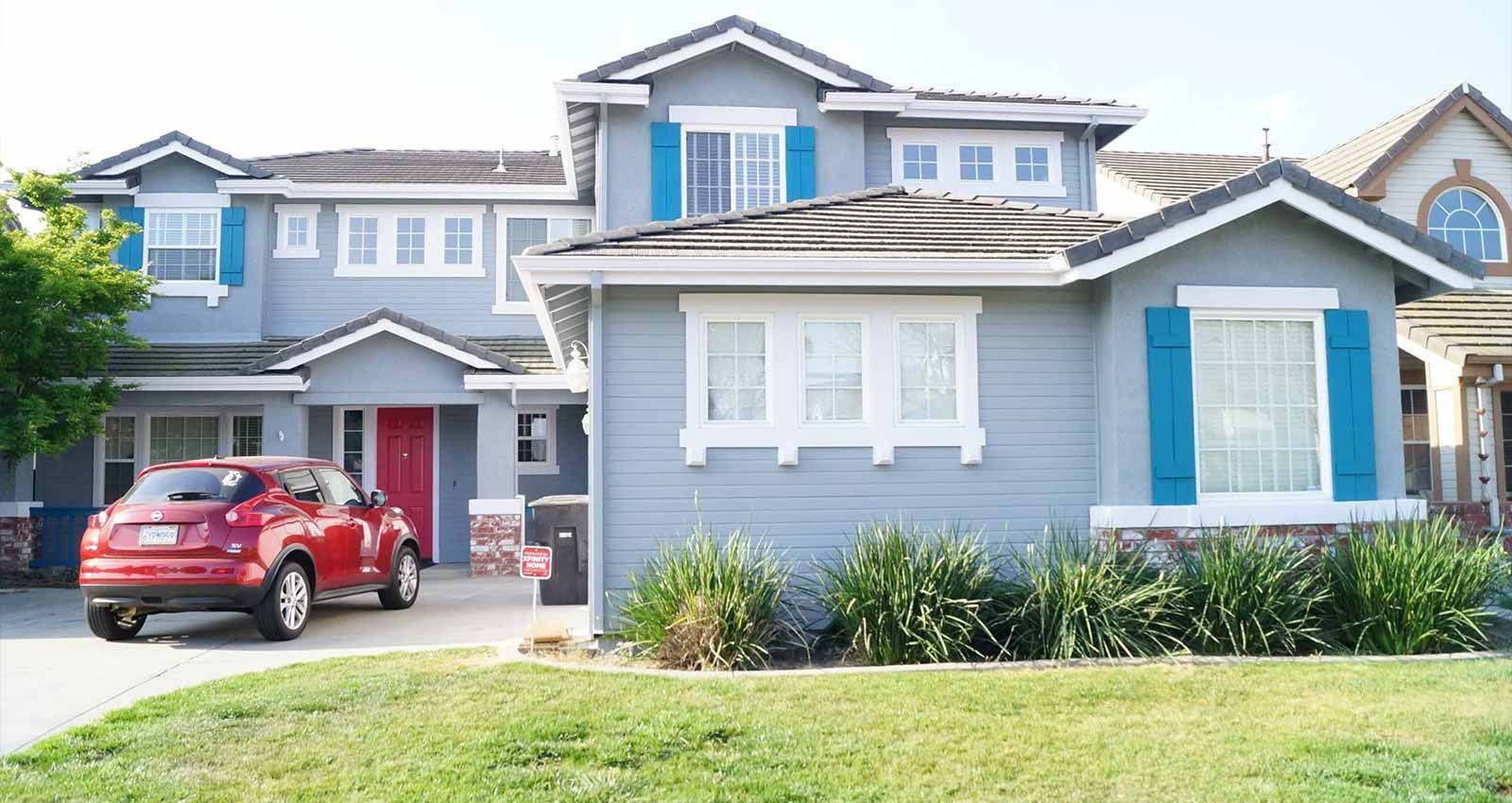 A large house with a red car parked in front of it