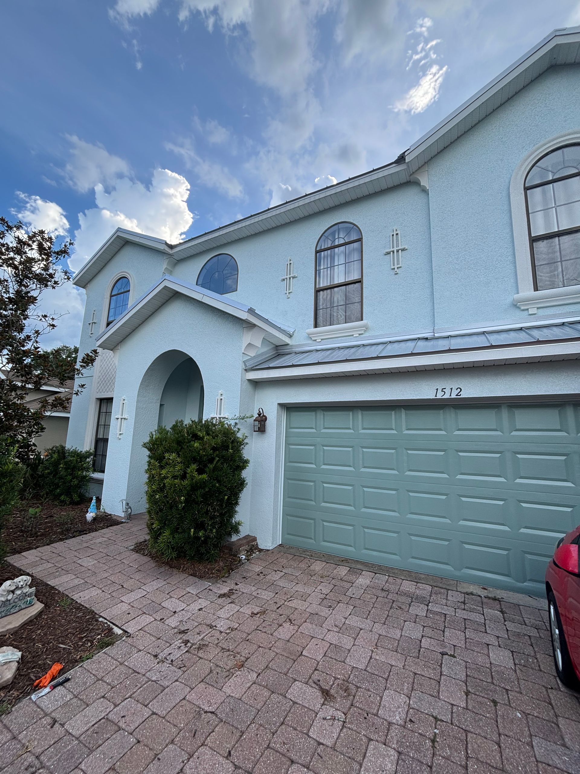 Two-story home in a DeLand, FL HOA community after professional exterior painting by Atlantic Finish, including pressure washing, stucco crack sealing, and two coats of Sherwin-Williams Duration exterior paint