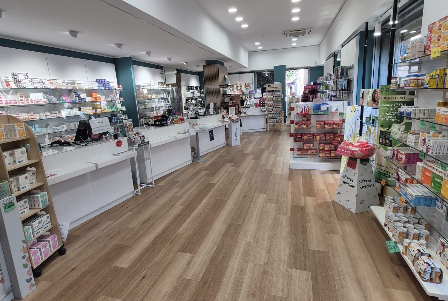 The inside of a pharmacy with wooden floors and shelves filled with lots of products.
