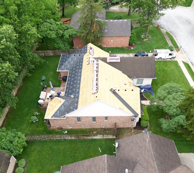 An aerial view of a house with a new roof being installed.