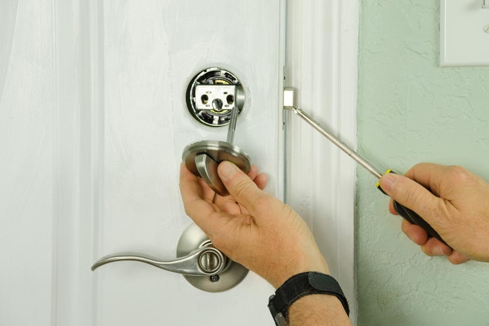 door lock repairs with screw driver on white door