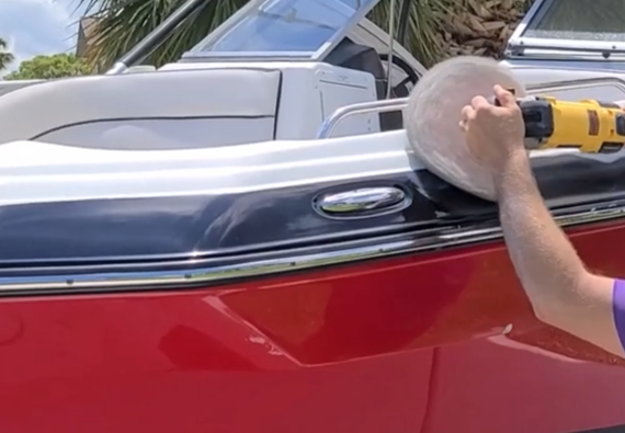 operator with buffer polisher working on boat