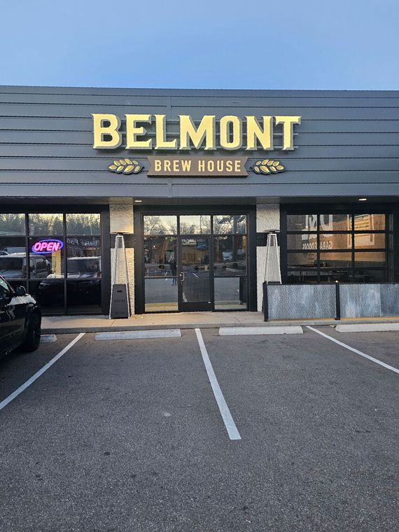 A belmont brew house building with a parking lot in front of it
