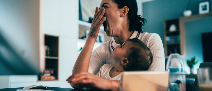 Tired woman with baby on her lap