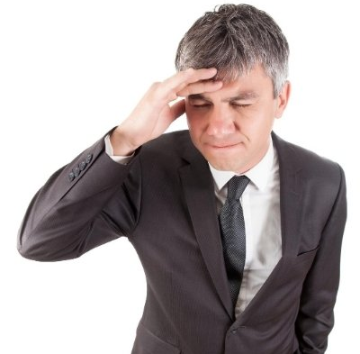 stressed businessman with hand on forehead
